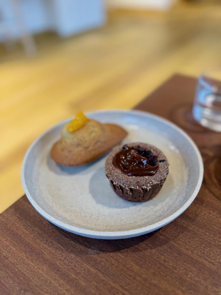 Fondant au chocolat et madeleine aux agrumes dans une assiette en grès grise