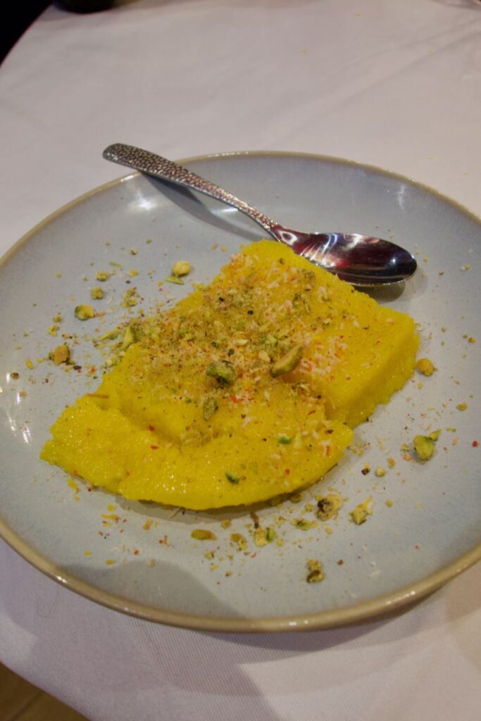 Gâteau de semoule dans une assiette grise avec une cuillère ornée