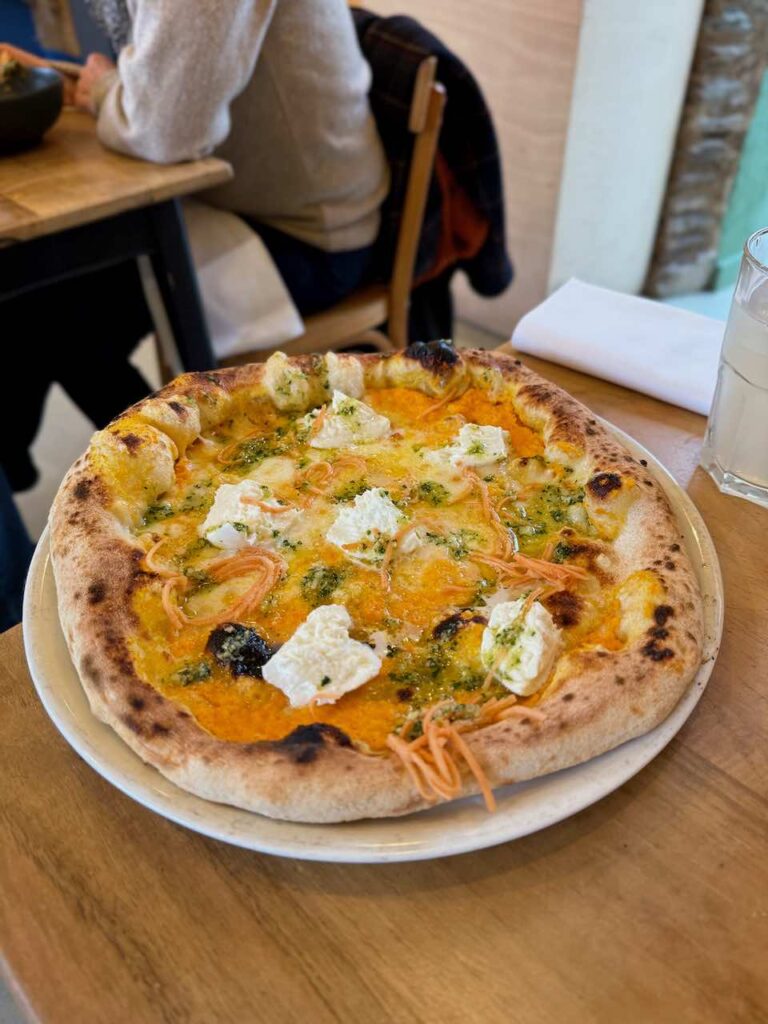 Pizza napolitaine dans une grande assiette blanche sur une table en bois