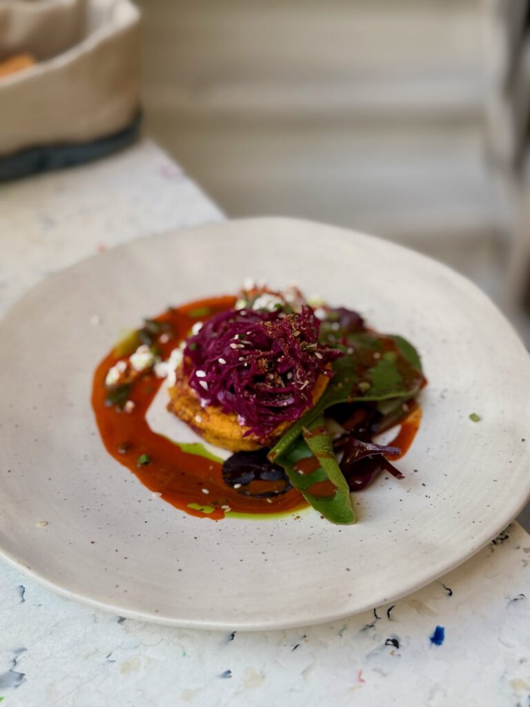 Flan de carotte et pickles de betterave dans une assiette en grès blanche mouchetée