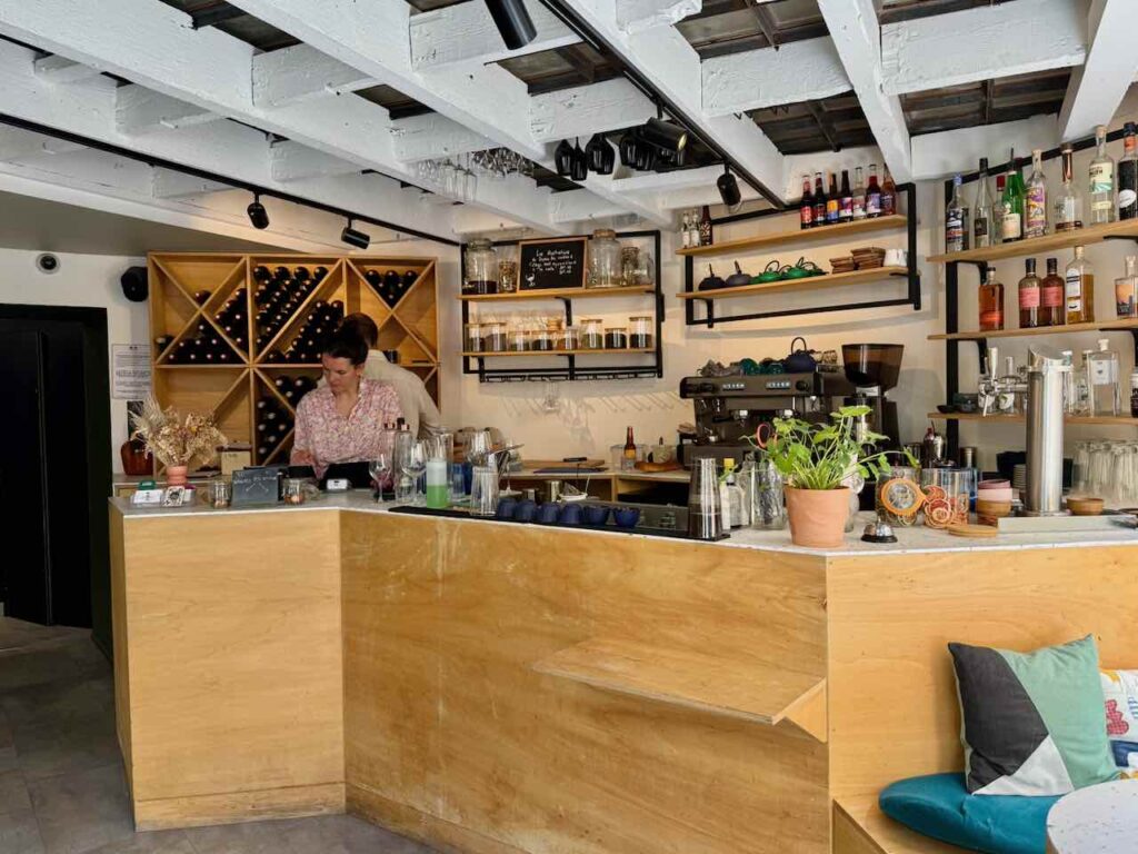 Zinc en bois au premier plan, bouteilles de vin et spiritueux au second plan