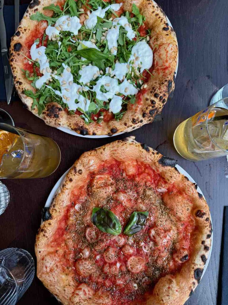 Deux pizza vues du dessus avec deux verres de thé glacé