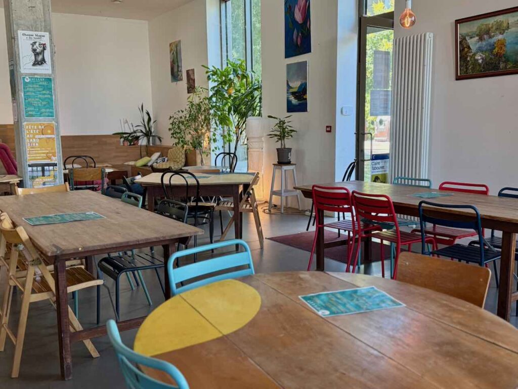 Intérieur du Labo Diva avec de grandes tables en bois et des chaises en métal