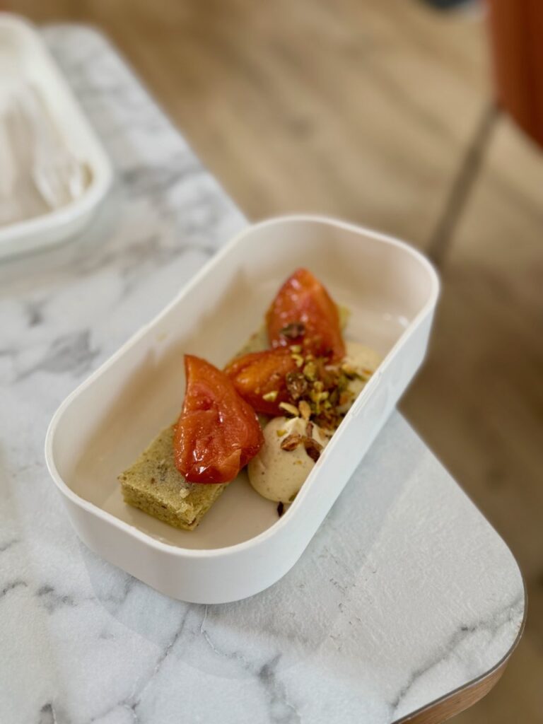 Moelleux pistache et abricots dans un bento blanc rectangulaire sur une table effet marbre