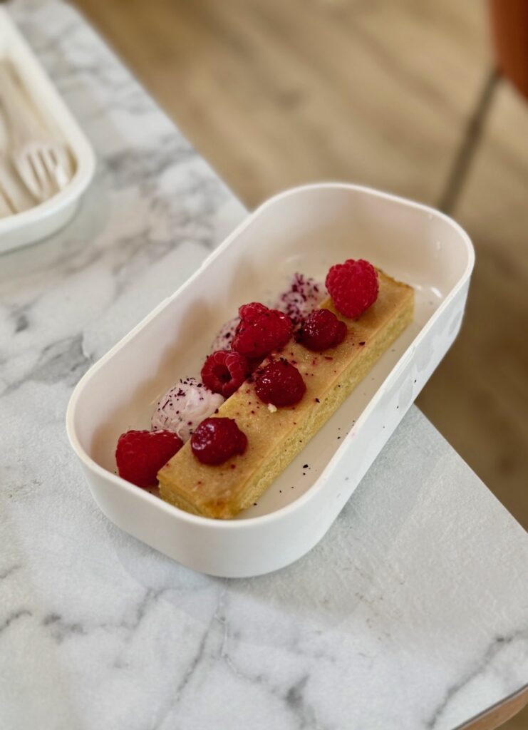 Gâteau rhubarbe dans un bento blanc rectangulaire sur une table effet marbre