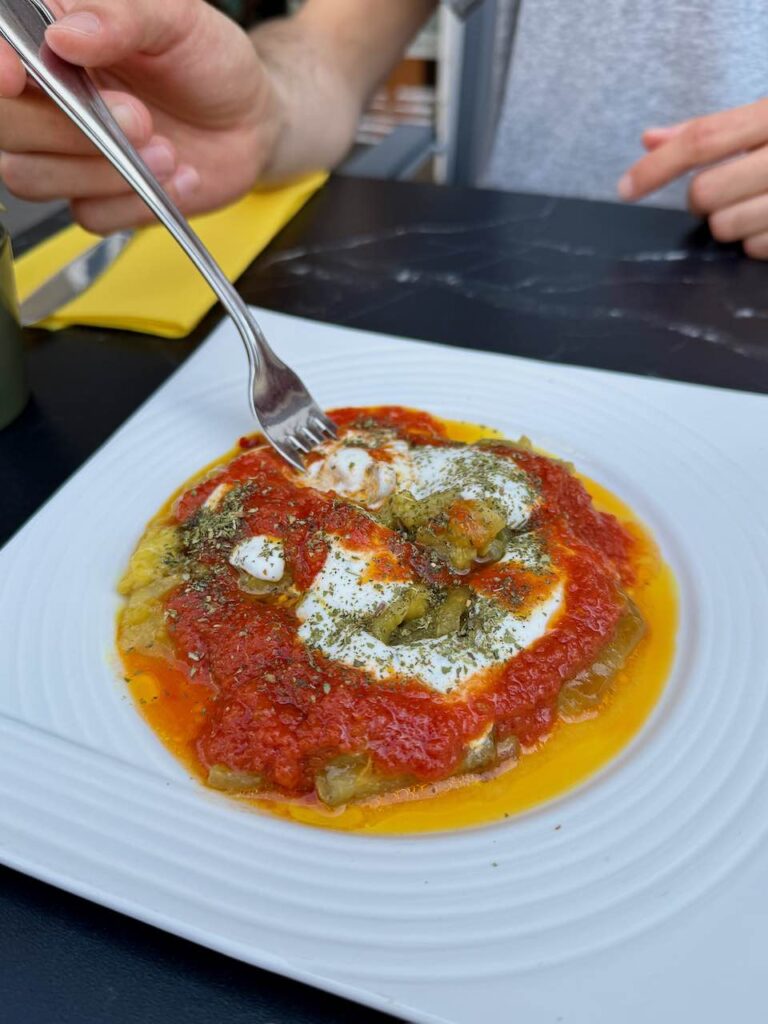Aubergines et sauce afghane dans une assiette blanche