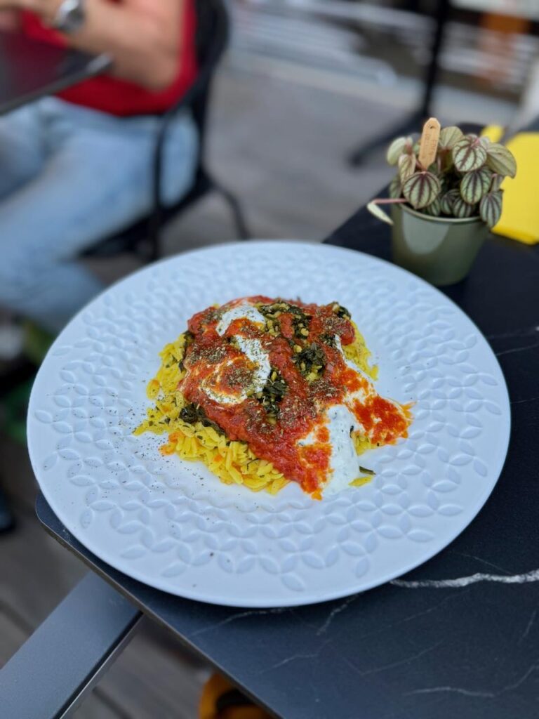 Pâtes au curcuma, sauce afghane dans une assiette blanche