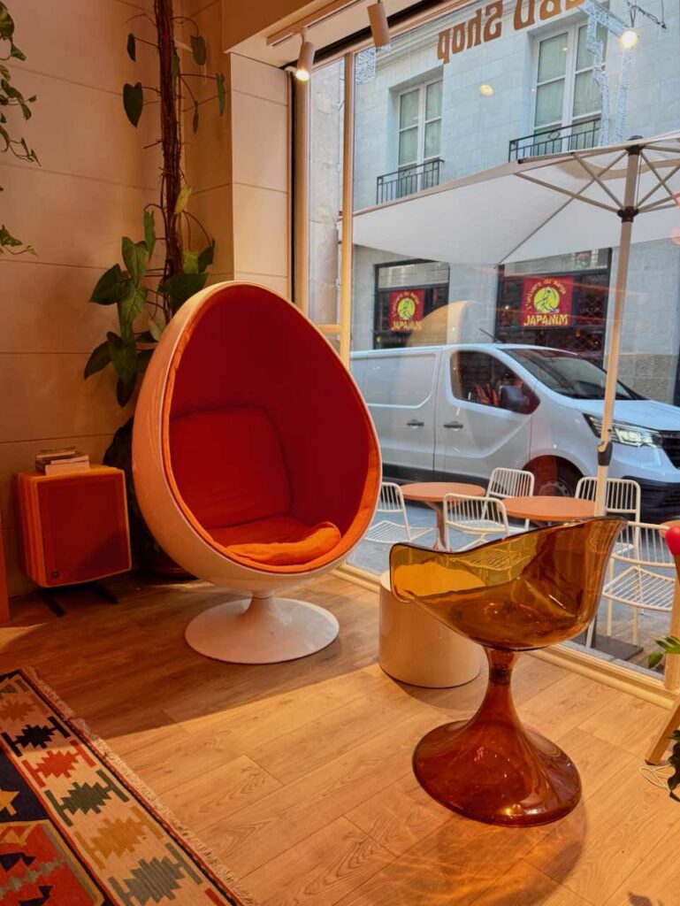 Fauteuil oeuf rotatif orange et blanc, chaise plastique transparent orange, parquet et tapis au sol