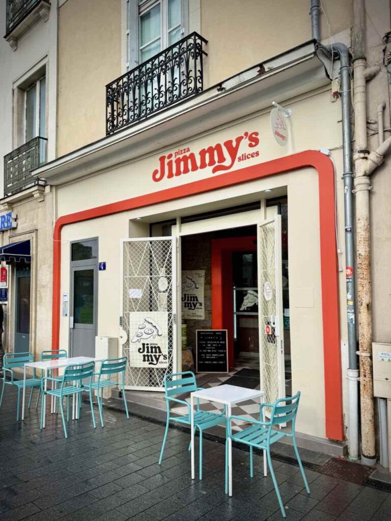 Devanture de la pizzéria blanche et rouge avec des grilles stylisées