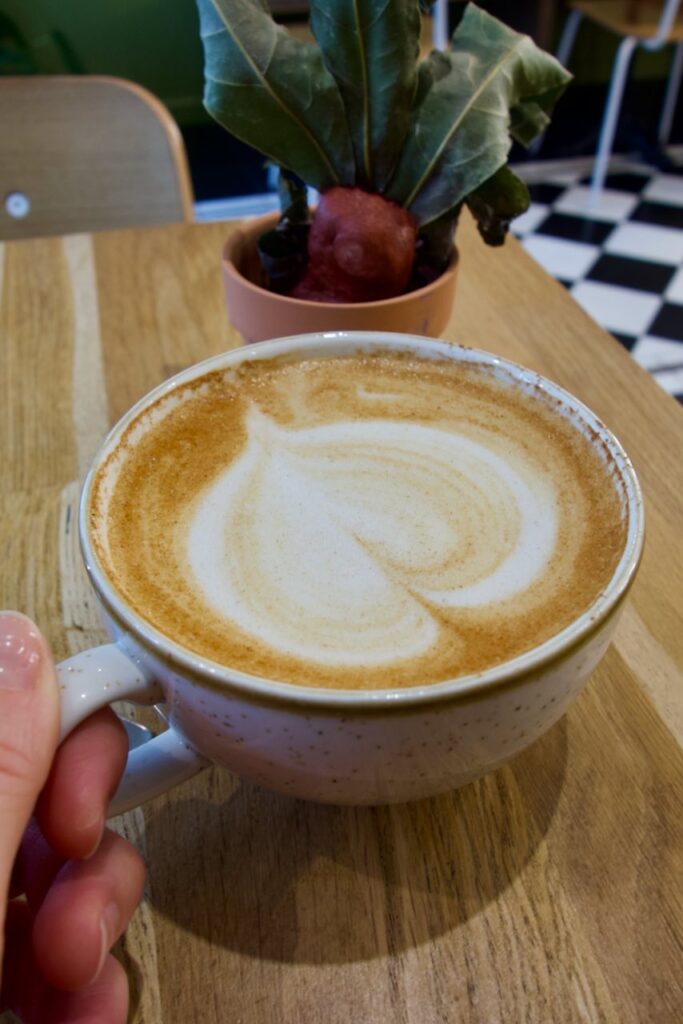 Pumpkin spice latte dans une tasse en grès gris clair mouchetée avec un coeur en latte art