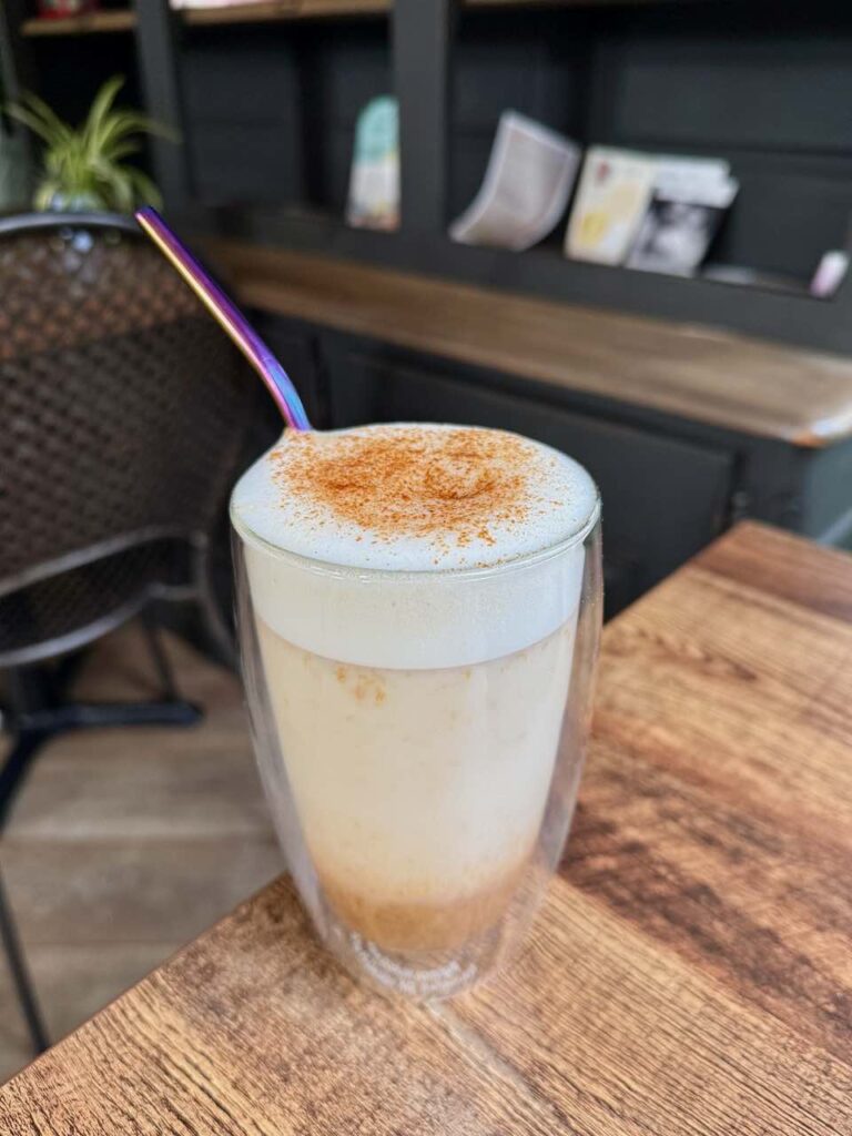 Pumpkin spice dont on voit les strates dans un grand verre double parois avec une paille en métal