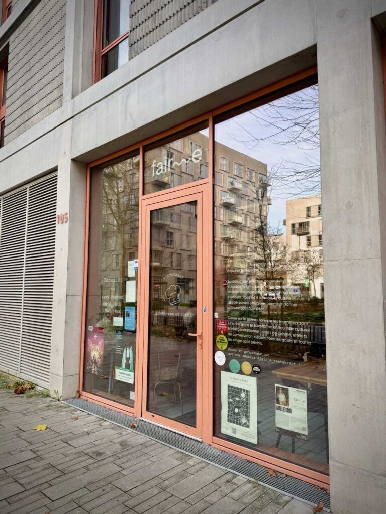 Devanture du restaurant avec une encadrure de porte terracotta et de grandes vitres
