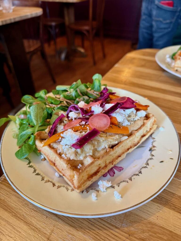 Gaufre salée accompagnée de mâche et de vinaigrette dans une assiette vintage à petite feuilles et liseré doré