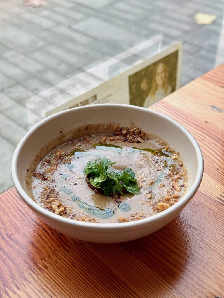 Velouté de champignons et persil dans un bol rond en porcelaine blanche