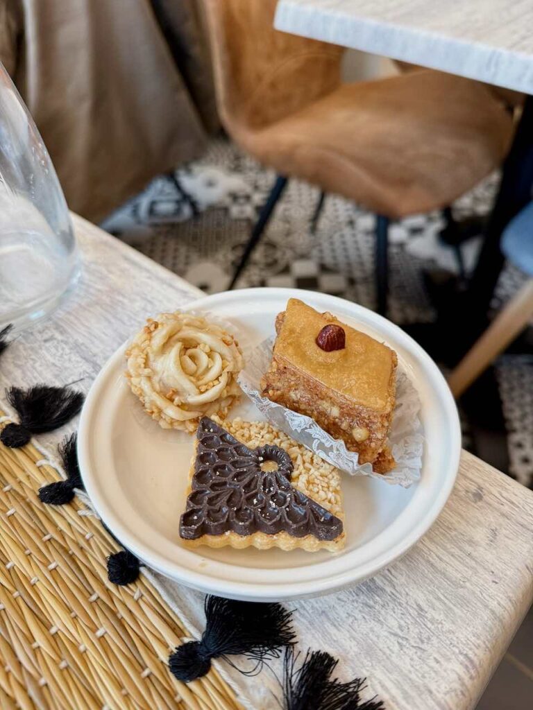 Sablé chocolat, rose amande et gâteau amande miel dans une assiette blanche