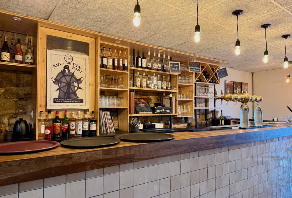 Zinc en mosaïque blanche et bouteilles sur des étagères en bois