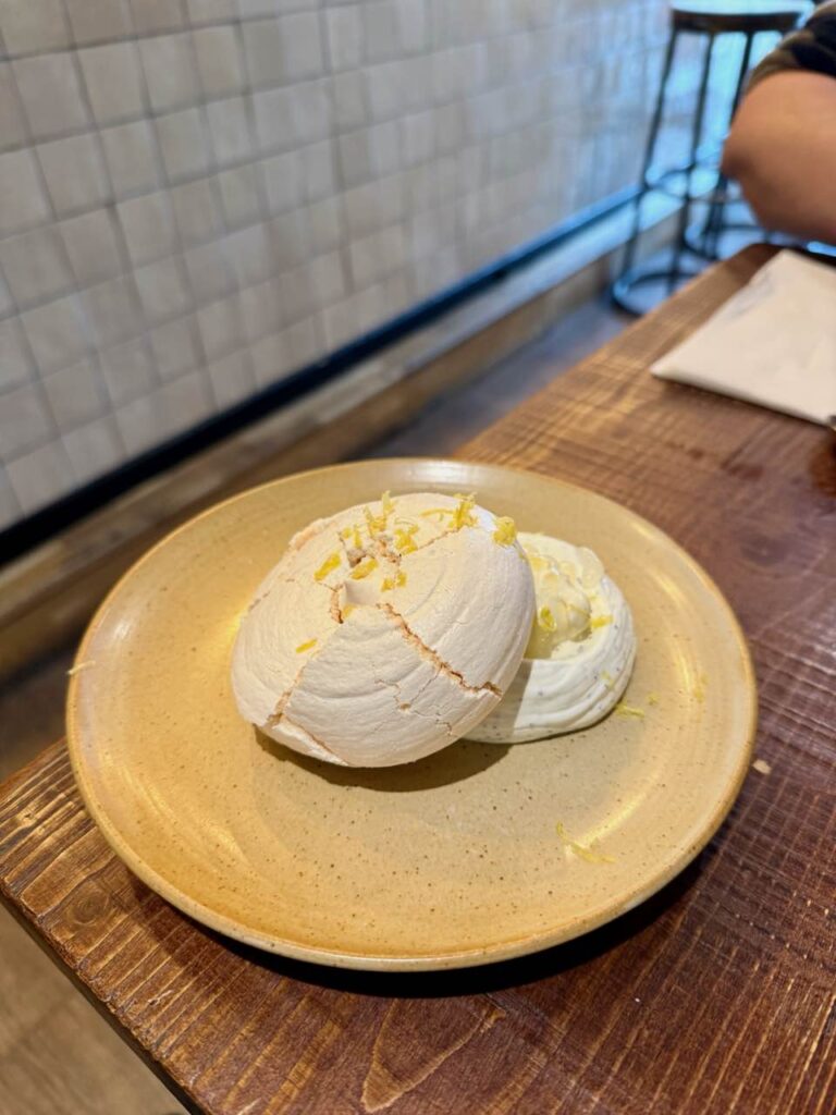 Meringue recouvrant une crème blanche dans une assiette en grès jaune