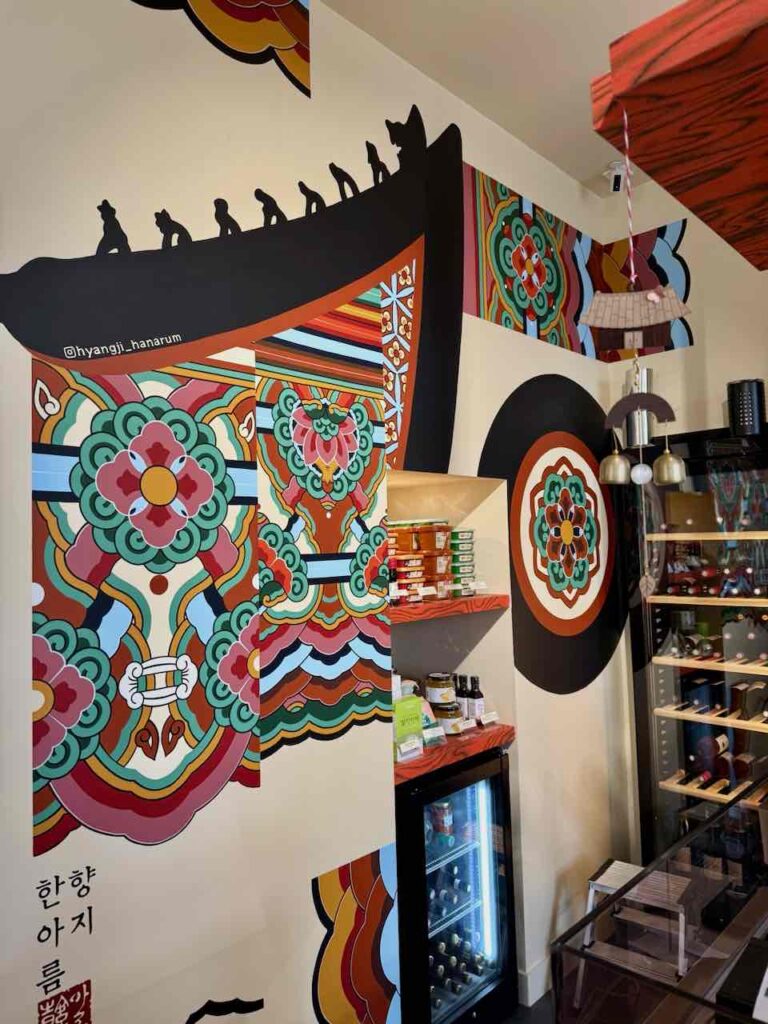 Fresque murale rappelant les peintures d'un temps coréen, petit coin épicerie et cave à vin réfrigérée