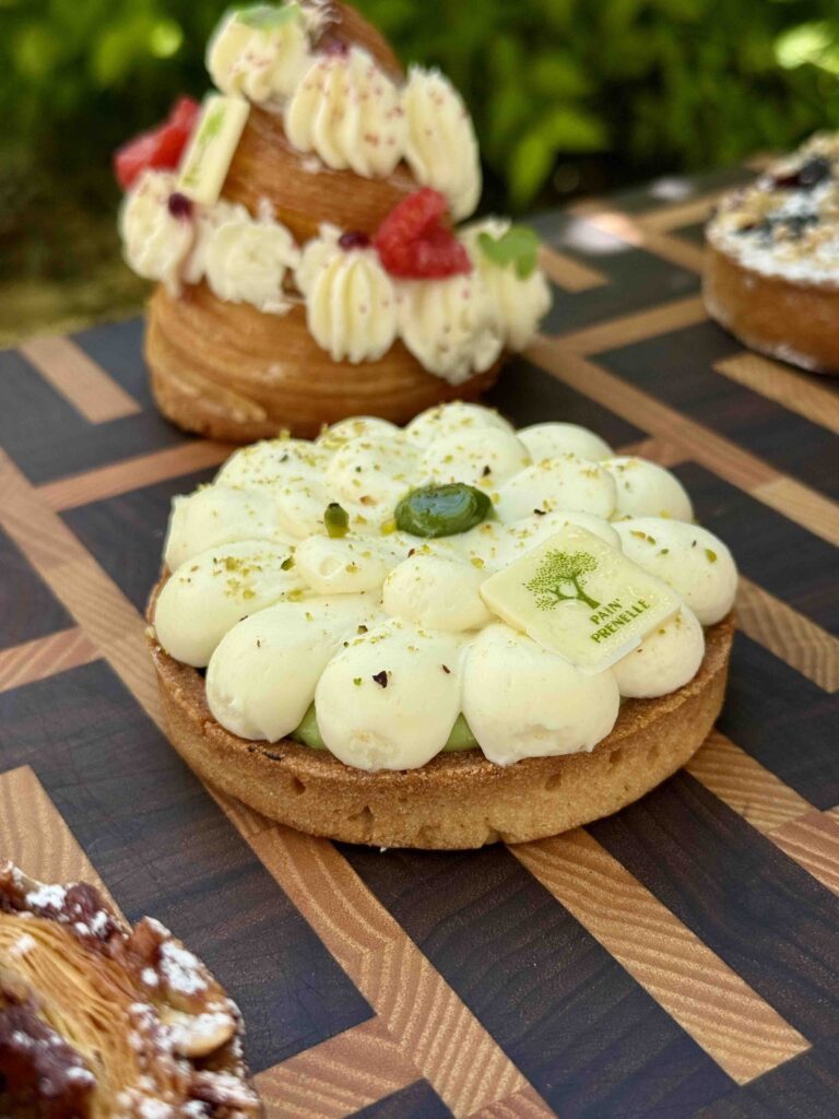 Tartelette blanche et verte en forme de fleur, posée sur une planche à découper design