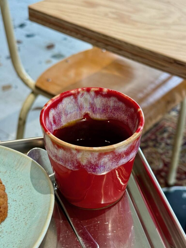 Café filtre dans une tase rouge sur un plateau en métal