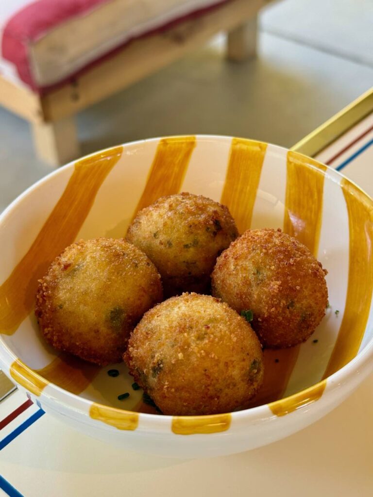 Cromesquis dorés dans un bol blanc à rayures jaunes