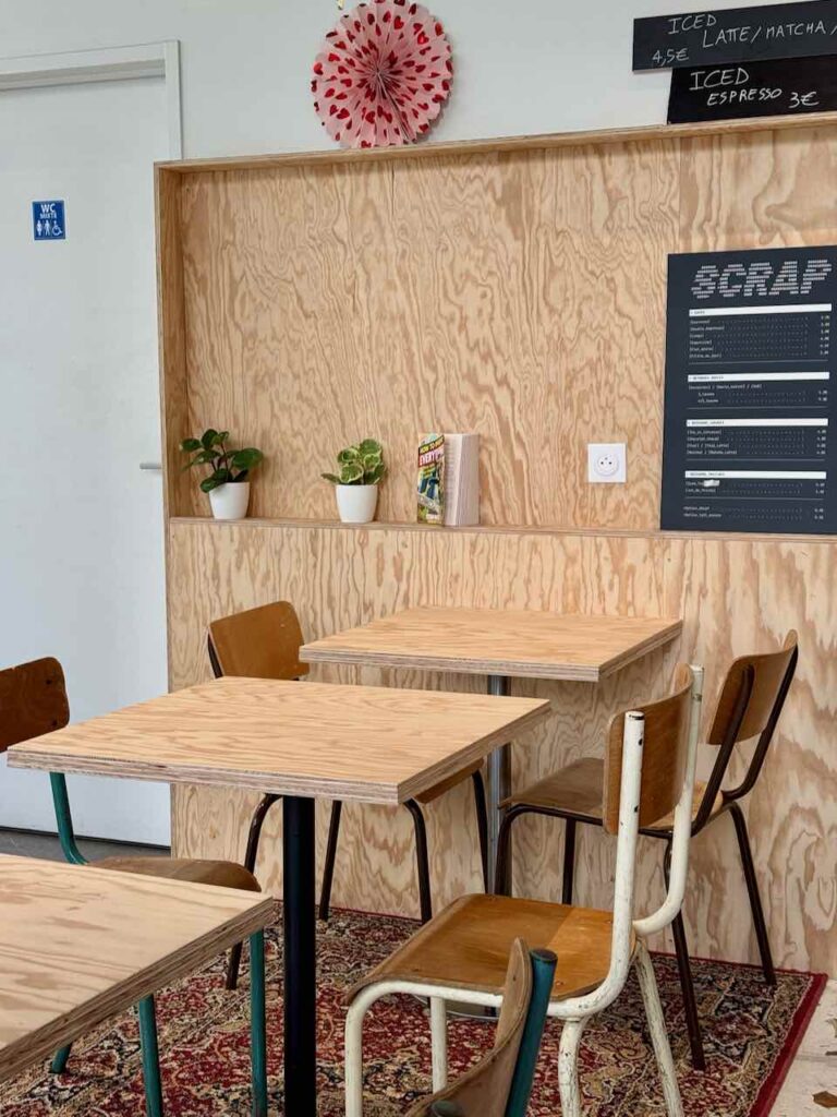 Intérieur de Scrap Café avec chaises d'école, tables en bois et bois au mur