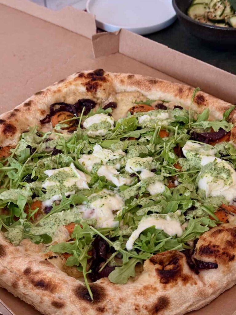 Vue plus globale de la pizza dans sa boîte