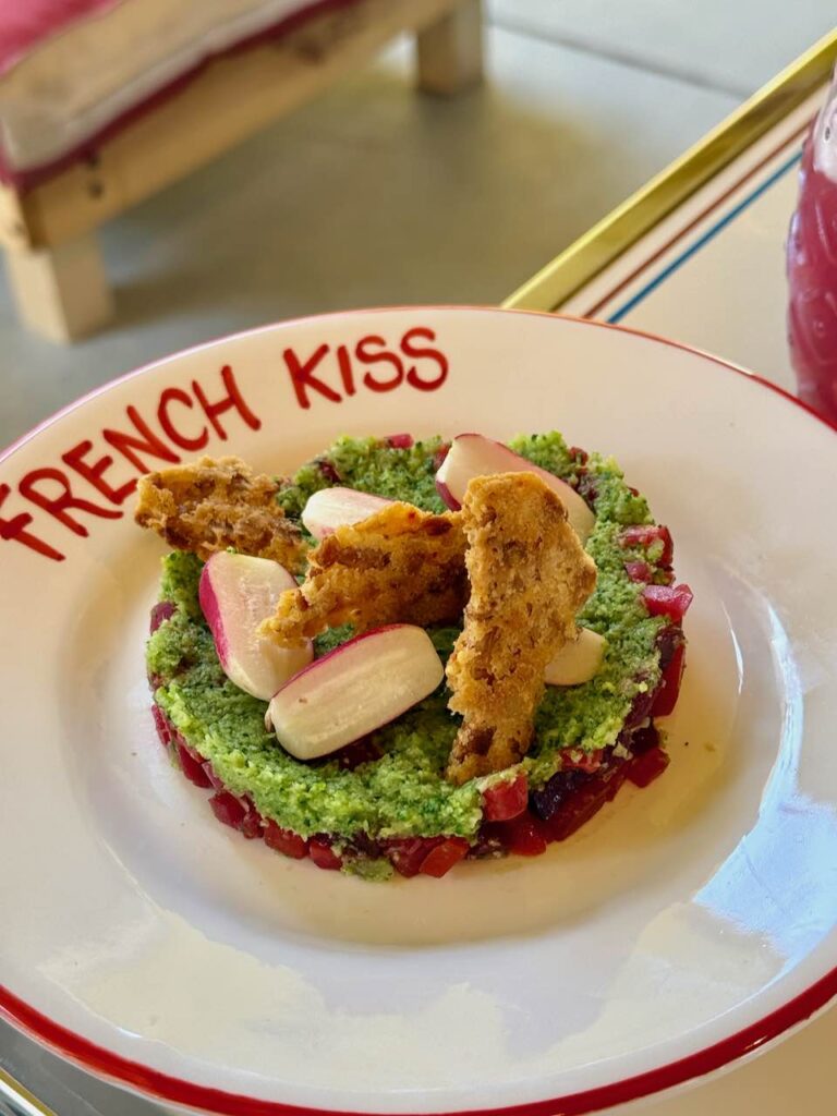 Tartare de betterave, radis et biscuit dans une assiette creuse blanche à liséré rouge avec le logo French Kiss