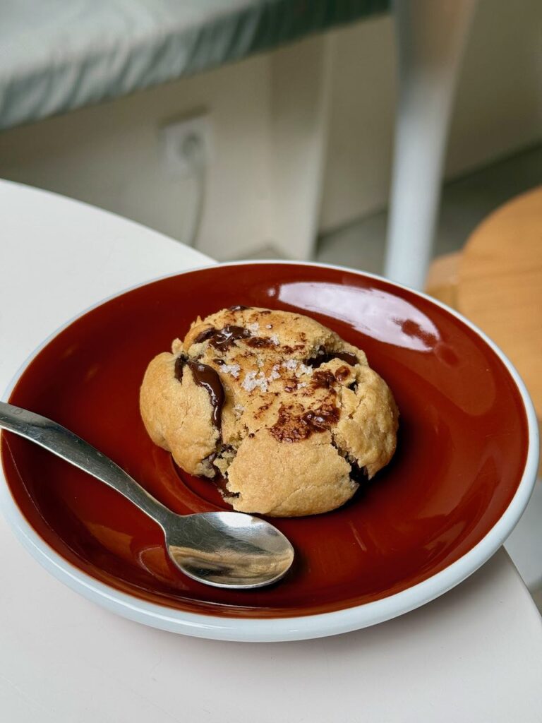 Cookie au chocolat dans une assiette rouge à liseré blanc