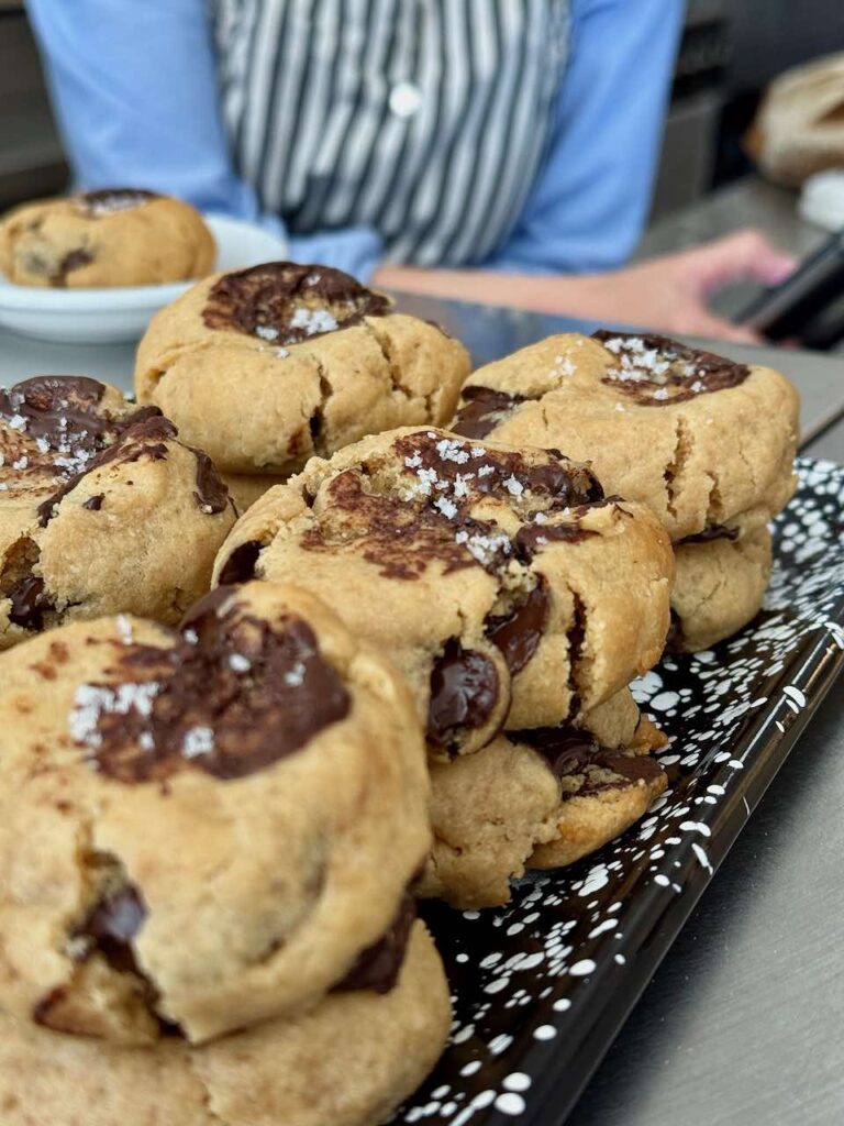 Cookie vegan aux pépites de chocolat et surmontés de fleur de sel sur un plateau noir à pois blancs