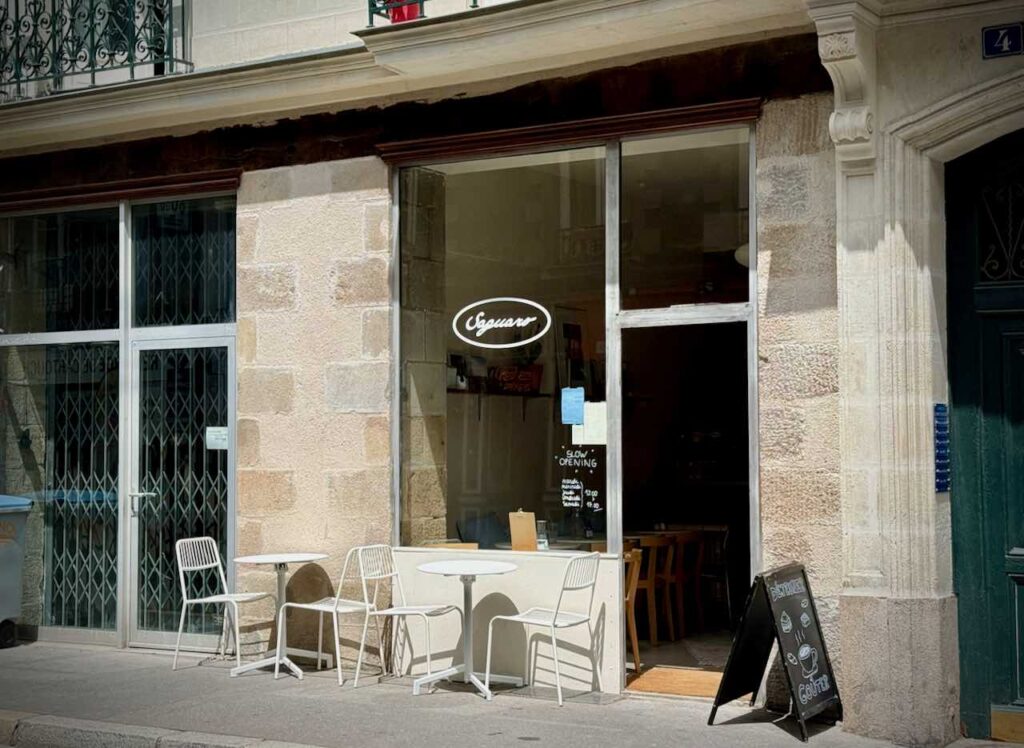 Devanture de Saguaro Coffee avec des chaises et tables blanches en terrasse