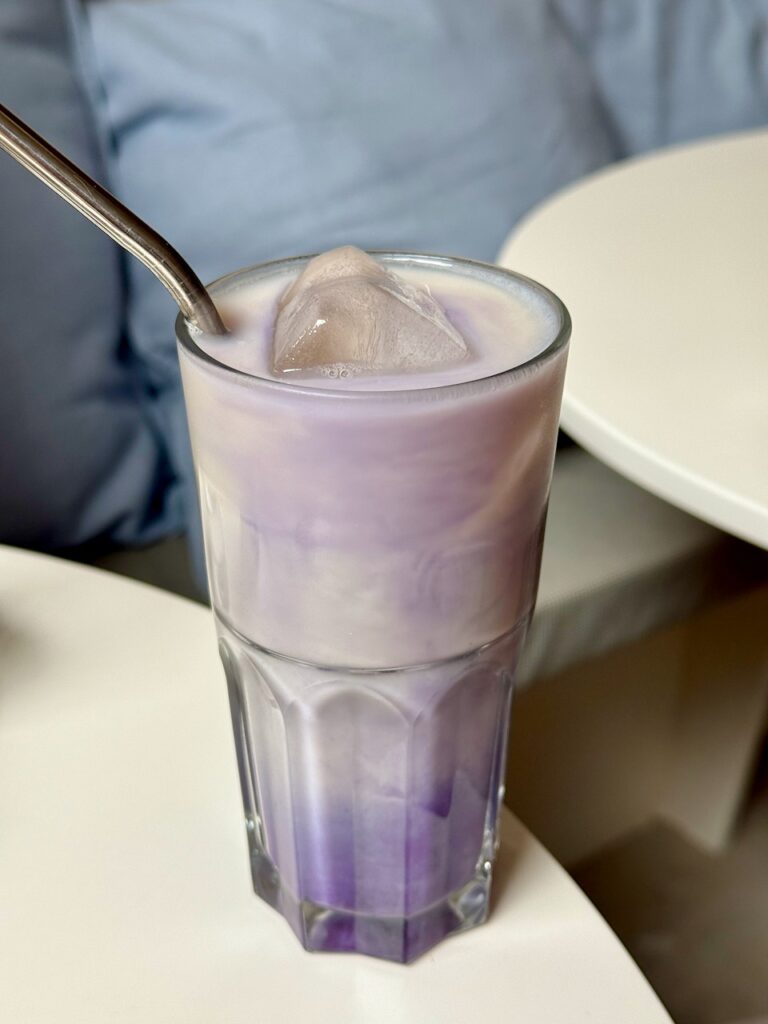 Ube latte avec paille en métal dans un grand verre transparent