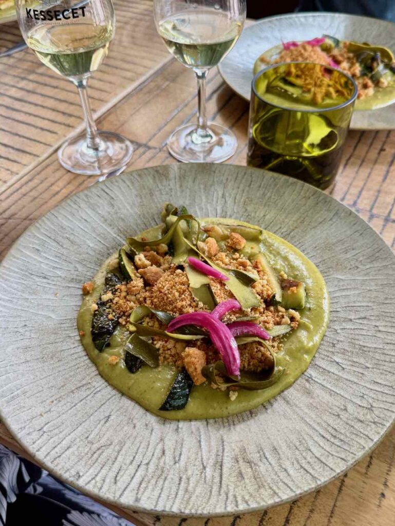 Courgettes tranches et lamelles, pickles roses, crumble dans une assiette grise