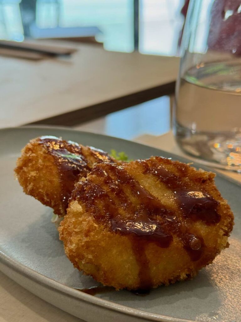 Gros plan sur deux croquettes surmontées de sauce