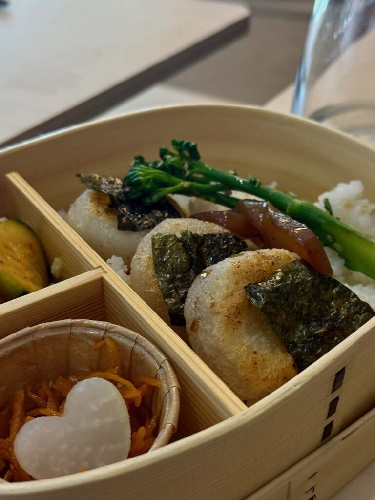 Gros plan sur les trois daikon mochi enveloppés dans du nori et accompagnés de branches de brocoli