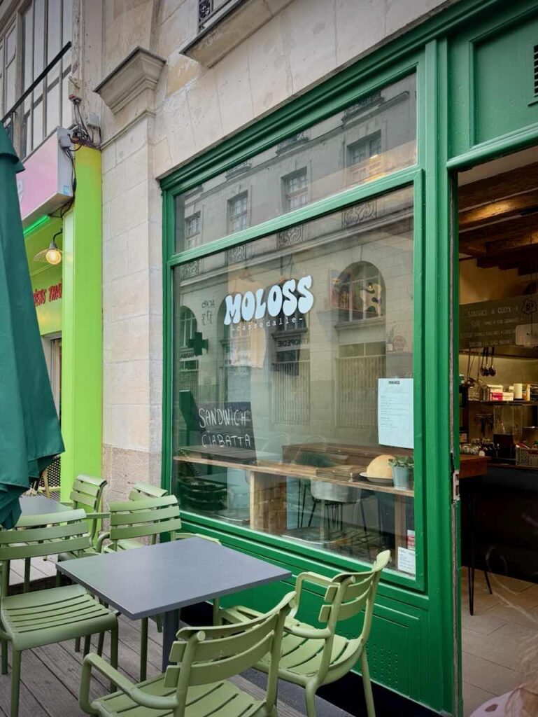 Devanture verte de Moloss et table et chaises d'extérieur devant