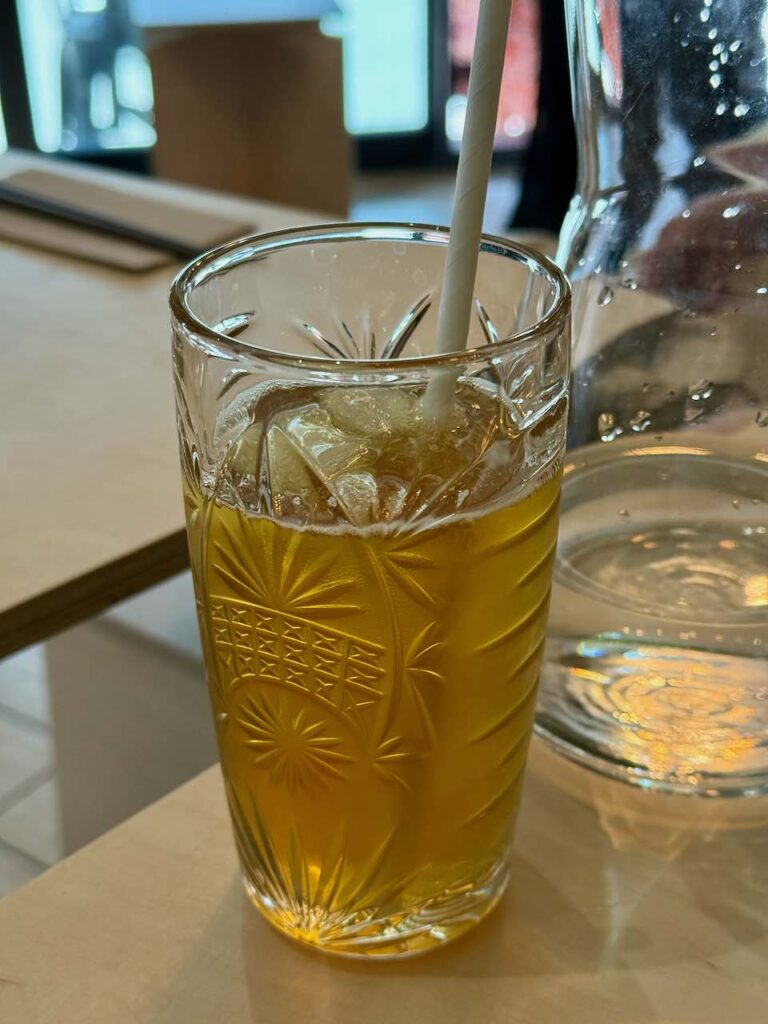 Thé glacé avec une paille dans un grand verre transparent