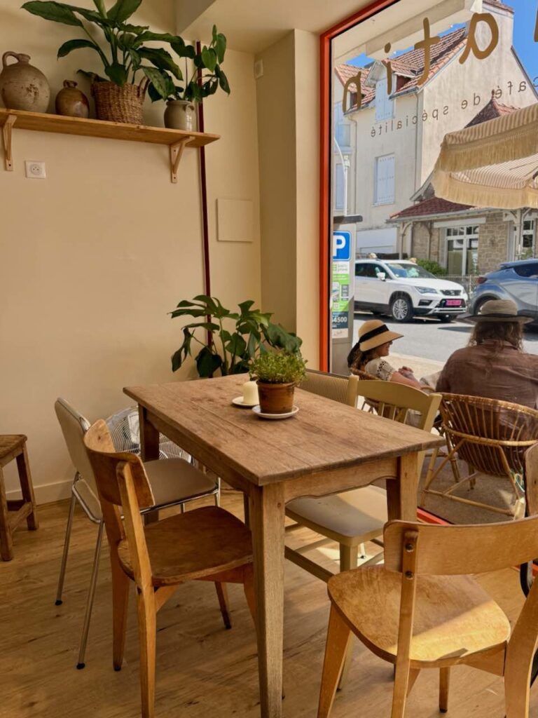 Intérieur avec table en bois et chaises en bois, plantes en pot sur une étagère