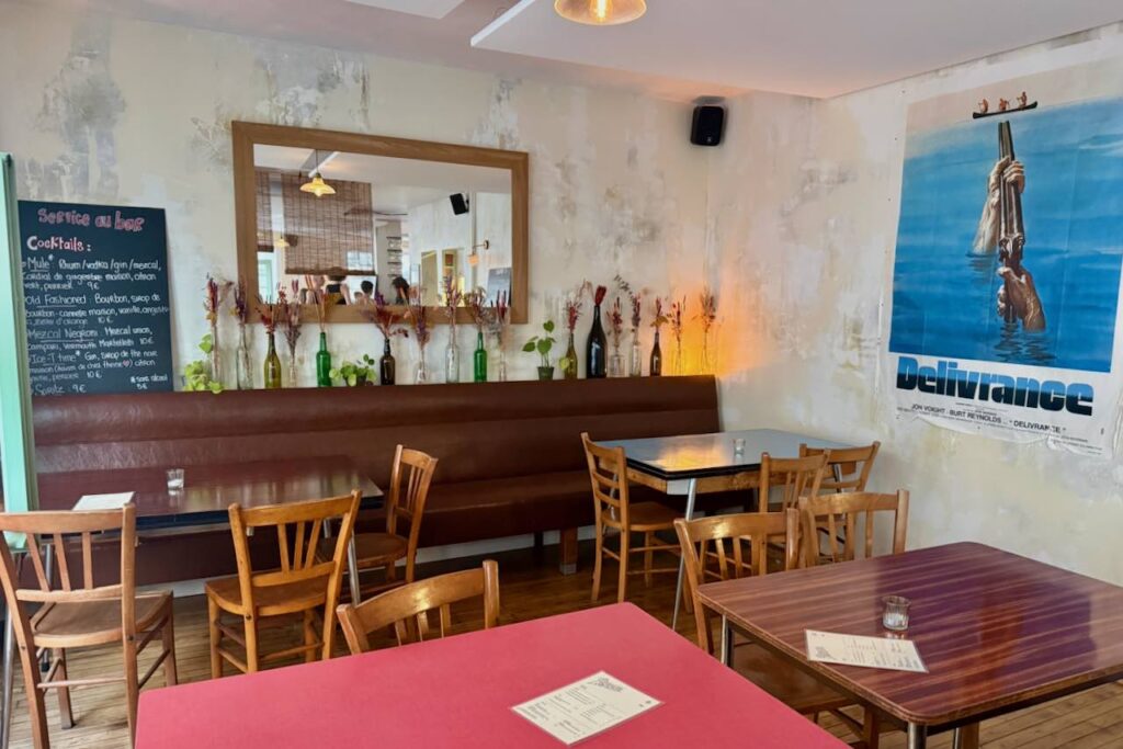 Intérieur banquette cuir, tables et chaises bistro en bois affiche de cinéma au mur