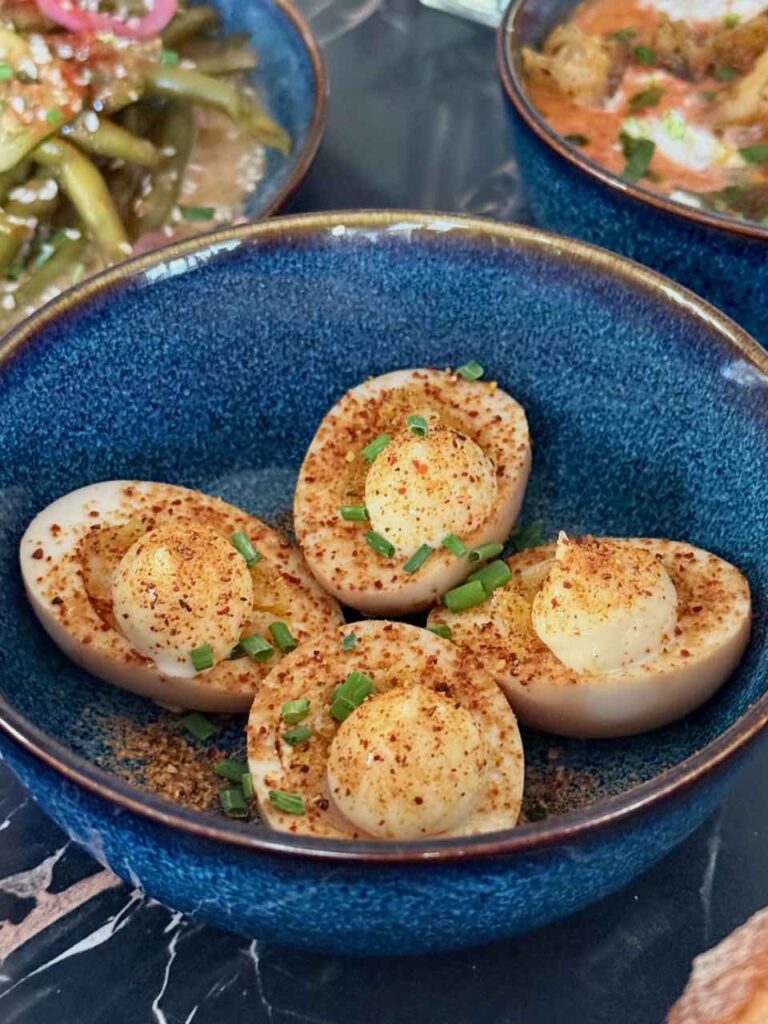 Quatre demi-oeufs surmontés de mayonnaise dans un bol bleu