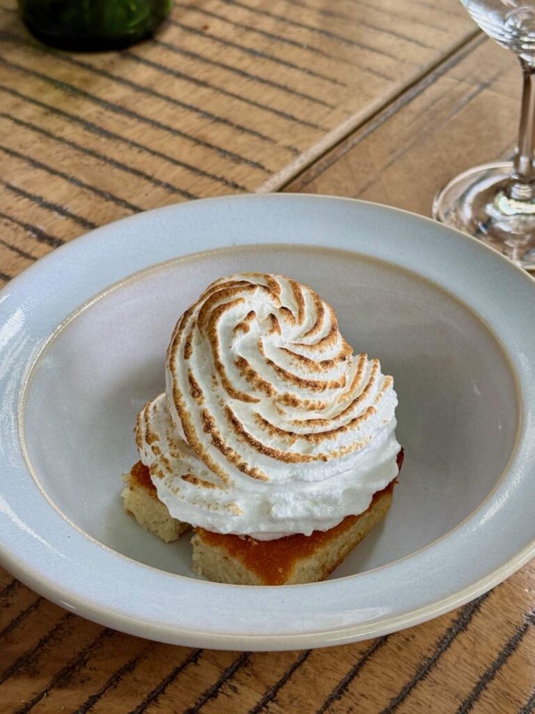 Meringue sur un biscuit carré dans une assiette creuse blanche