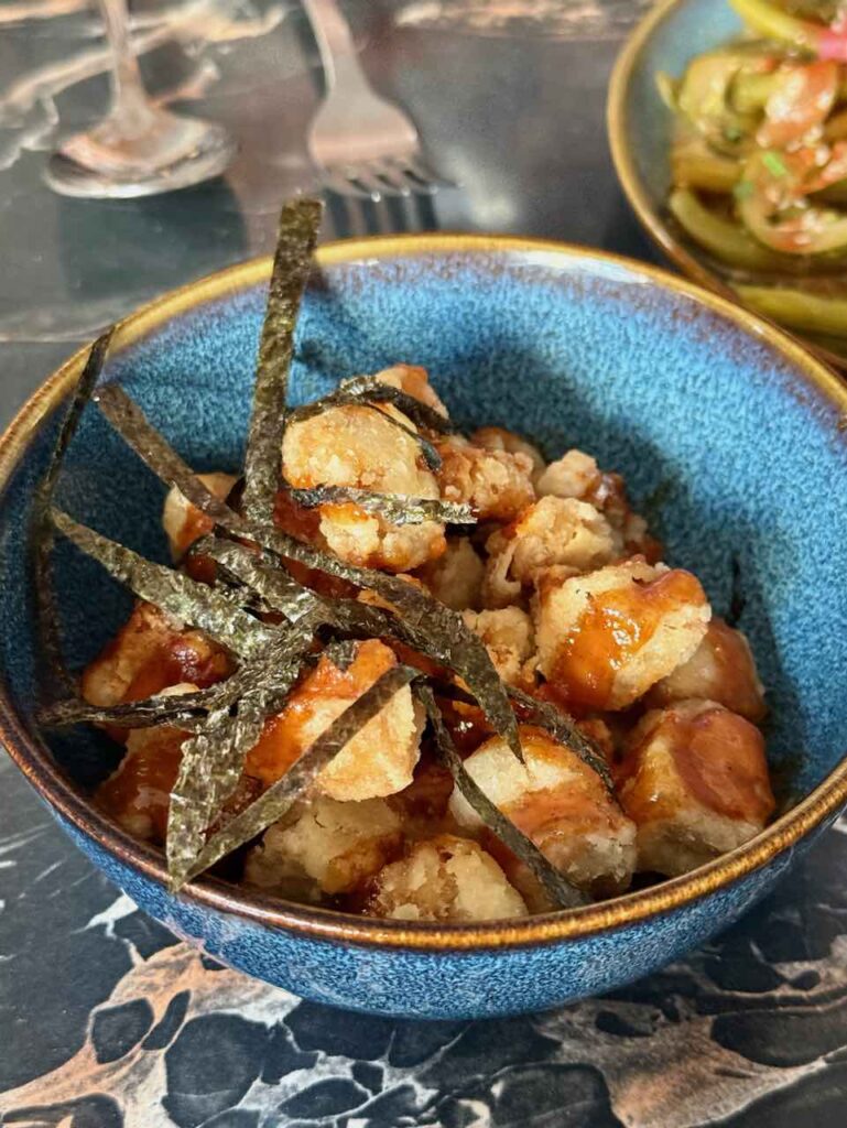 Cubes de tofu frit surmontés de lamelles de nori dans un bol bleu