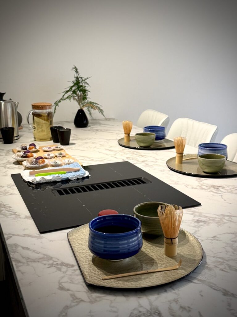 Îlot entral en marbre avec préparations pour wagashi, sets pour cérémonie de thé matcha et thé vert infué