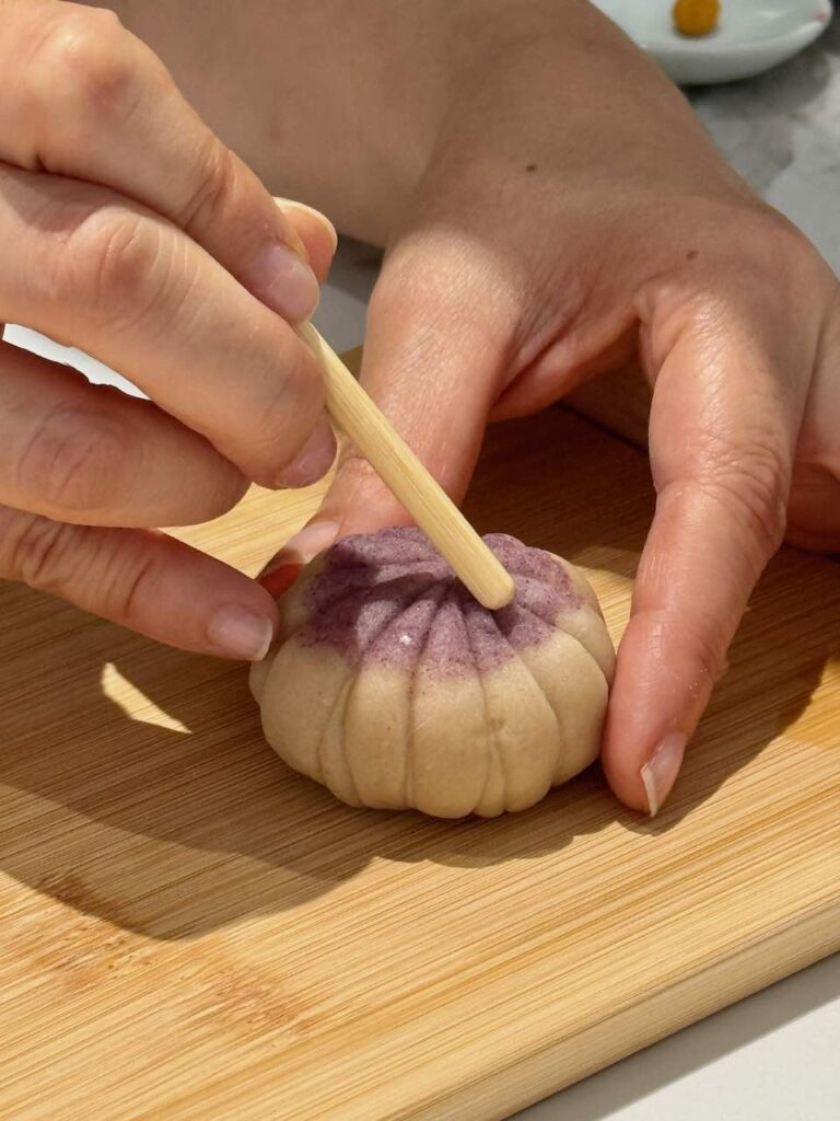 Personne creusant un wagashi avec un bâton rond